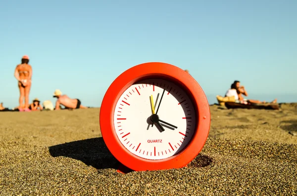 Klok op het zandstrand — Stockfoto