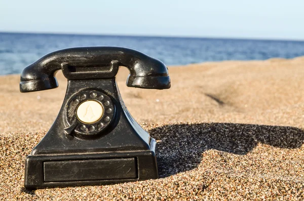 Teléfono en la playa de arena — Foto de Stock