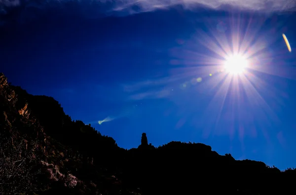 Bir dağ silueti üzerinde mavi bir gökyüzü güneş Star'da — Stok fotoğraf