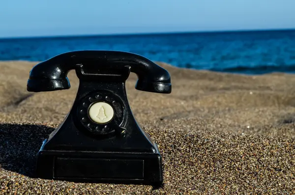 Teléfono en la playa de arena — Foto de Stock