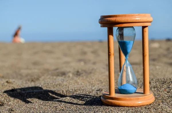 Zandloper klok aan het zand strand — Stockfoto