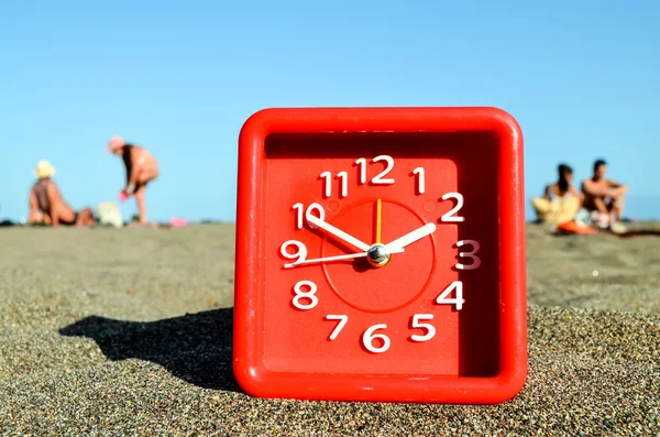 Klok op het zandstrand — Stockfoto