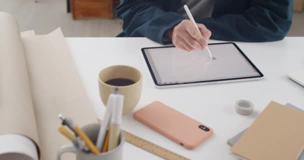 Erkek kişi tablete resim çiziyor ve rahat bir iş yerinde otururken resim oluşturuyor. Masada proje üzerinde çalışırken stil ve ped kullanan web tasarımcısı. Yaratıcılık ve sanat kavramı. — Stok video