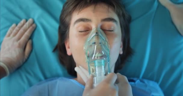 Paramedici zetten zuurstof inhalatie masker op meisje gezicht terwijl ze haar proberen te redden. Millennial vrouwelijke patiënt sterven terwijl liggend op vervoer brancard en naar het ziekenhuis. — Stockvideo