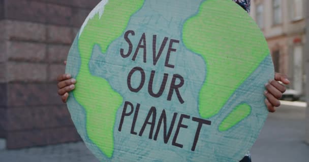 Nahaufnahme einer afrikanisch-amerikanischen Person, die ein Modell der Erde in der Hand hält, um unseren Planeten zu retten. Weibliche Hände mit Plakat bei einem einzigen Protest gegen Umweltverschmutzung. Konzept der Ökologie. — Stockvideo