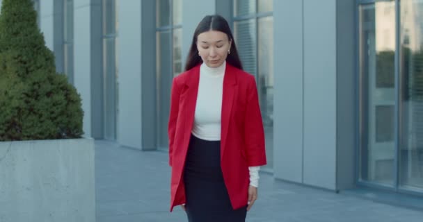 Kameraya bakıp selamlayan Asyalı iş kadınının portresi. Sokakta durup saygı ve resmiyet kavramını kucaklayan çekici kadın manzarası.. — Stok video