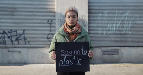 Lviv, Ucrania - 27 de noviembre de 2019: Jovencita sosteniendo pancarta con decir no al plástico mientras está parada en la calle vacía. Mujer milenaria en huelga por la ecología. Concepto de Salvar la Tierra. — Vídeo de stock