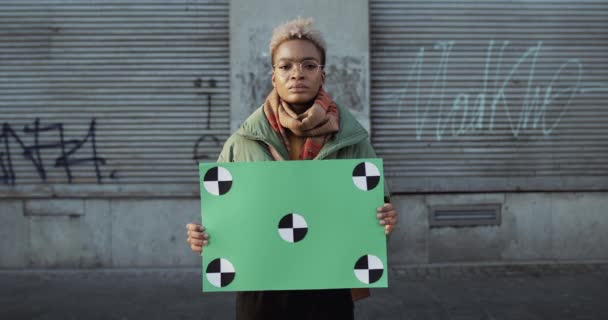 Lviv, Ukraine - November 27, 2019: Woman standing at empty street and holding placard with tracking points. Millennial female protesting with banner. Copy space. Blank green screen board. — Stock Video