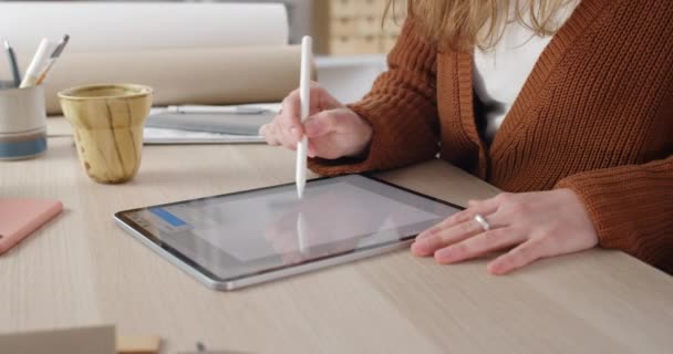 Crop view van vrouwelijke webdesigner kiezen borstel grootte tijdens het tekenen van digitale afbeelding. Focus op de handen van de vrouw met behulp van stylus, terwijl het creëren van illustratie op tafel.Concept van de moderne kunst. — Stockvideo