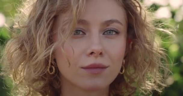 Portrait de jolie femme aux cheveux blonds courts tournant la tête et regardant vers la caméra. Gros plan de la jeune femme souriante tout en posant. Concept de style de vie. Fond vert flou. — Video