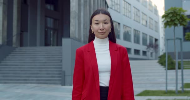कॅमेरा शोधत कोंबडी ऑफिस पोशाख मध्ये यशस्वी तरुण स्त्रीचे पोर्ट्रेट. पीक दृश्य सकारात्मक आशियाई व्यवसाय महिला व्यवसाय क्षेत्रातील शहर रस्त्यावर चालत. व्यवसाय संकल्पना . — स्टॉक व्हिडिओ