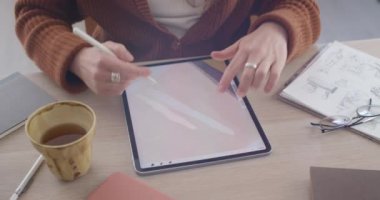 Tablet ve dönen ekranda resimleme oluşturan kadın grafik tasarımcısının kırpma görünümü. İş yerinde otururken dijital ped ve stil kullanarak talanted illüstratör. Sanat kavramı.