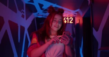 Akıllı telefon, kaydırma ve dokunmatik ekran kullanırken çekici tombul kadın mutlu görünüyor. Kadın kulüp üyesi neon ışıkları ve parlayan sayılarla salonda yürürken gülüyor..