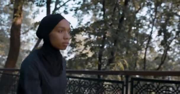 Crop view van mooie moslim vrouw in sportpak op zoek naar slimme horloge tijdens het joggen. Jonge vrouw in hijab die in het park rent. Concept van gezonde levensstijl, sport. — Stockvideo