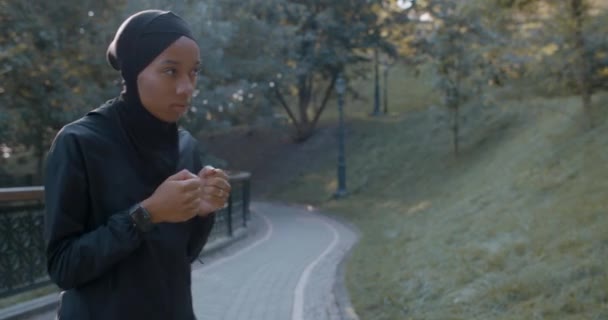 Schnitte Ansicht der jungen hübschen muslimischen Frau in Sportanzug Boxen allein. Weibliche Person im Hidschab beim Selbsttraining im Park. Konzept eines gesunden Lebensstils, Sport. — Stockvideo