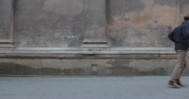 Şehir caddesinde dans eden şapkalı afro-amerikalı şık bir adam. Havalı giysiler içinde, elinde kağıt kahve fincanı ve el işi poşeti taşırken ay yürüyüşü yapan neşeli sakallı bir adam. Açık havada..