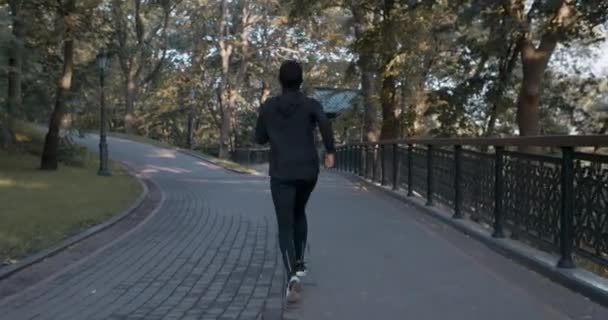 Baksidan på kvinnan som springer i parken. Full längd tillbaka syn på kvinnlig person i hijab och sport kostym jogging. Begreppet hälsosam livsstil, idrott. Utomhus. — Stockvideo
