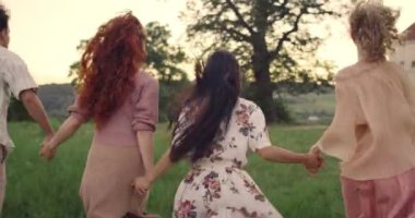 Çeşitli gençlerin bir arada durması ve koşarken el kaldırması. Milenyum arkadaşları parkta birlikte vakit geçiriyorlar. Dostluk ve rahatlık kavramı.