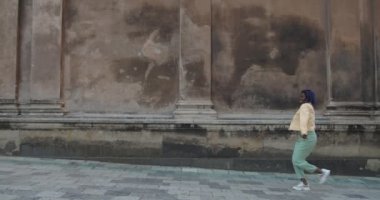 Milenyum kadınları eski şehir caddesinde yürürken dans etmeyi bırakırlar. Rastalı Afro-Amerikalı kadın kafiyeli hareket ederken mutlu görünüyor. Olumlu duygular kavramı.