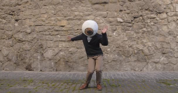 Positiv afro amerikansk manlig dansare med stora ögon mask huvudbonader dansar på gamla stan gatan. Killen i trendiga kläder rör sig och har roligt. Begreppet gott humör, positiva känslor. — Stockvideo