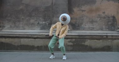 Eski şehir caddesinde kafa dansı üzerine kağıt gözlü Afro-Amerikalı. Bilinmeyen kadın tuhaf hareketler yapıyor. Keyif anlayışı, eğlence.