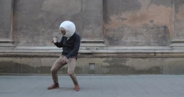 Eski şehir caddesinde büyük gözlüklü Afro-Amerikan erkek dansçı. Elinde kağıt kahve fincanı tutarken tuhaf hareketler yapan bilinmeyen bir adam. Keyif anlayışı, eğlence.