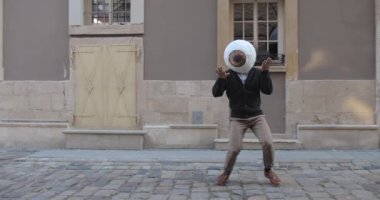 Eski şehir caddesinde, büyük göz maskeli Afro-Amerikan erkek dansçı. Moda kıyafetleri içinde tanınmayan bir adam taşınıyor ve eğleniyor. İyi ruh hali kavramı, olumlu duygular..