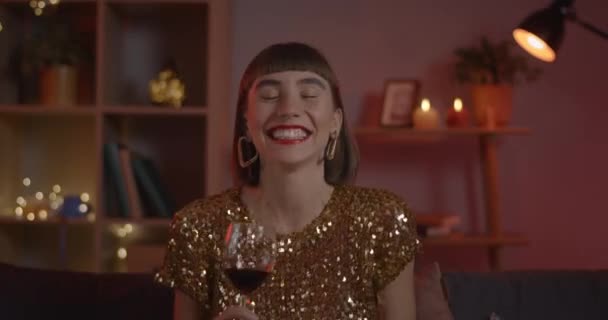 Attraktiv kvinna glädjande och dricka vin samtidigt ha online-samtal. Millennial glad kvinnlig person pratar och ler medan du tittar på kameran hemma. Begreppet online-datum. — Stockvideo