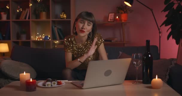 Schnittansicht einer attraktiven jungen Frau, die während eines Online-Gesprächs spricht und gestikuliert. Modische Millennial-Frau pustet Küsse, während sie zu Hause auf den Laptop schaut. — Stockvideo