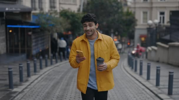 Hombre usando el móvil para la dirección mientras camina en un lugar nuevo — Vídeos de Stock