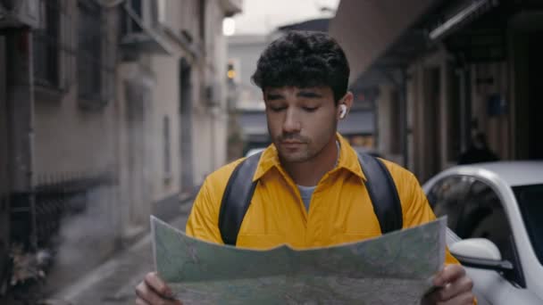 男性観光客が手に地図で通りを歩く — ストック動画