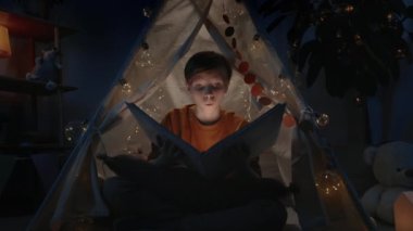 Akşamları evdeki derme çatma kulübede sarı saçlı heyecanlı çocuk. El feneriyle kitap okurken yerde oturan bir genç. Boş zaman ve boş zaman kavramı.