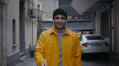 Kulaklıklı mutlu adam müzik dinliyor ve sokakta dans ediyor.