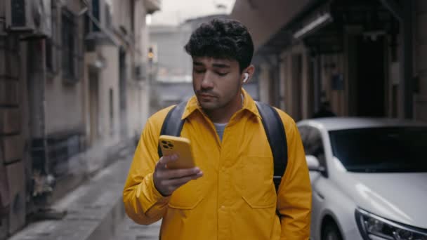 Homme utilisant écouteurs et smartphone pour explorer la nouvelle ville — Video