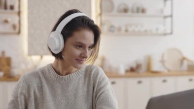 İnternet ağları sırasında kulaklık takan bir kadın not alıyor