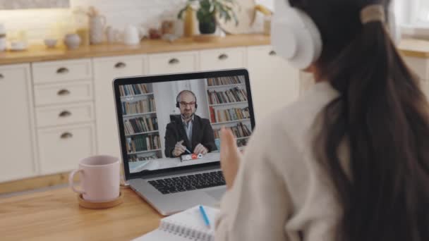 Vrouwelijke student met behulp van laptop voor video gesprek met tutor — Stockvideo
