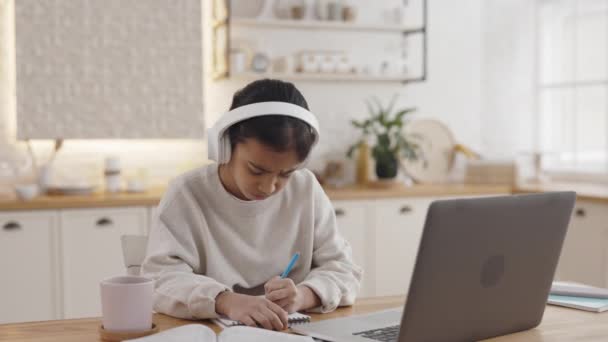 Olyckliga muslimska barn i hörlurar som studerar hemma — Stockvideo