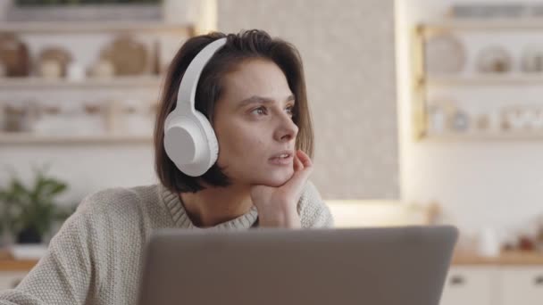 Mujer de ensueño usando portátil y auriculares para la educación en el hogar — Vídeo de stock