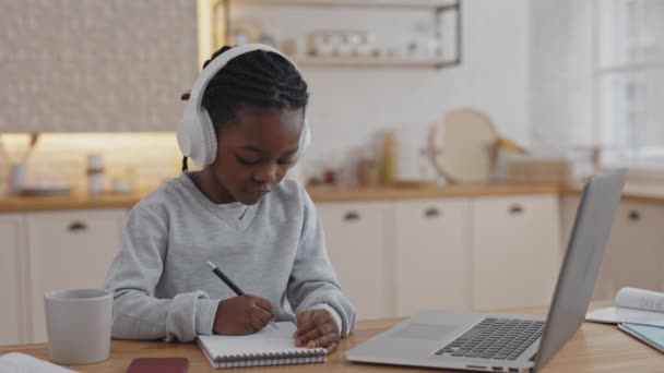 Afro μαθητής σε ακουστικά ακούει δάσκαλος κατά τη διάρκεια της βιντεοκλήσης — Αρχείο Βίντεο