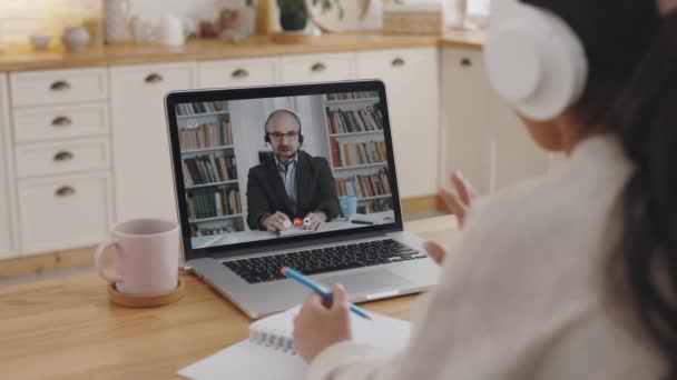 Vrouwelijke student begroeting tutor tijdens online les op laptop — Stockvideo