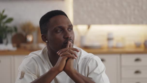Afrikansk man sitter ensam hemma med sina tankar — Stockvideo