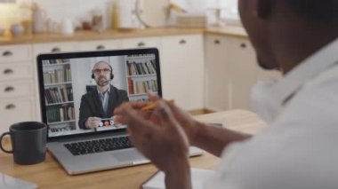 Afrikalı adam özel öğretmenle video görüşmesi için dizüstü bilgisayar kullanıyor