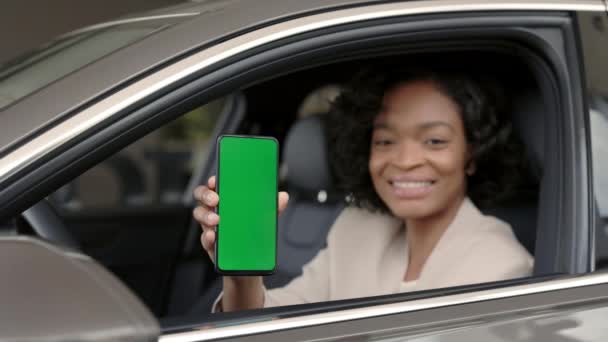 Mujer africana sosteniendo móvil con pantalla verde en el salón de coches — Vídeos de Stock