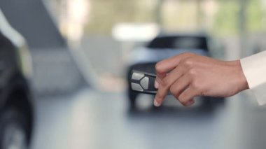 Araba yöneticisi müşteriye anahtar veriyor ve el sıkışıyor.