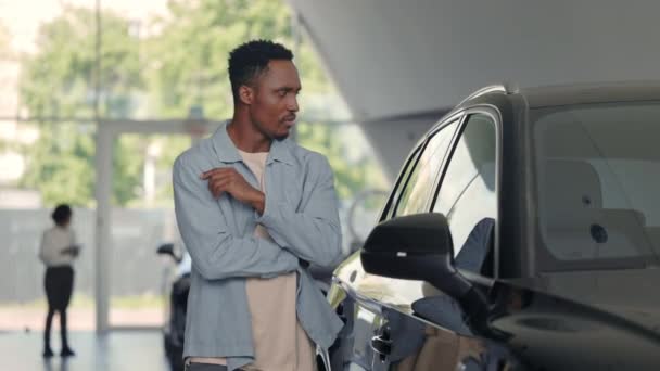 Hombre afroamericano eligiendo el coche en el salón de modenr — Vídeos de Stock