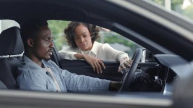 Modern arabayı erkek müşteriye sunan kadın satıcı.