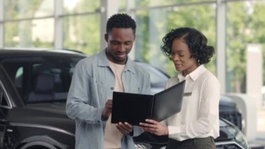 O kadını tutan adam panoya araba sözleşmesi imzalıyor.