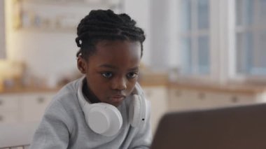 Afrikalı kız evde online eğitim için dizüstü bilgisayar kullanıyor