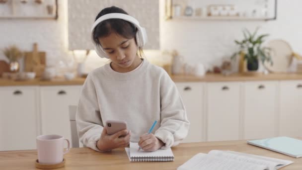Indian pupil using headphones and smartphone for education — Stock Video