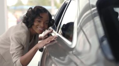 Kuaförde yeni bir arabanın yüzeyine dokunan Afrikalı Amerikalı kadın.